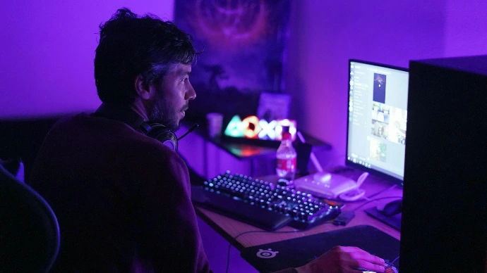 a man sitting in front of a computer monitor