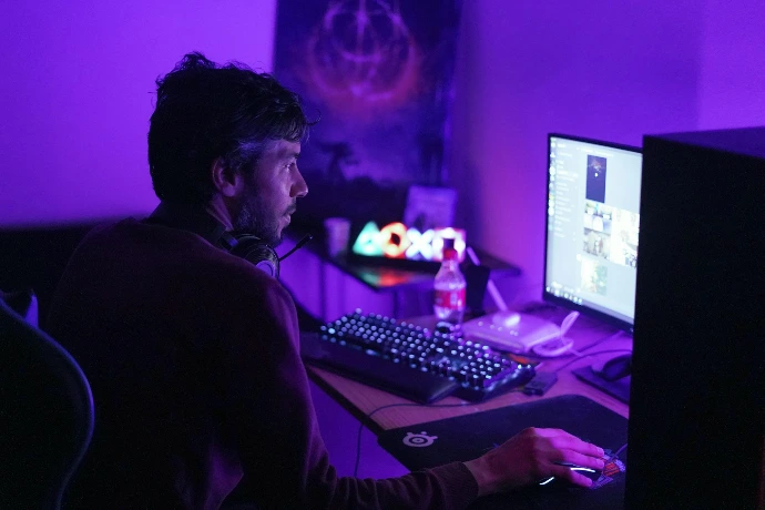 a man sitting in front of a computer monitor